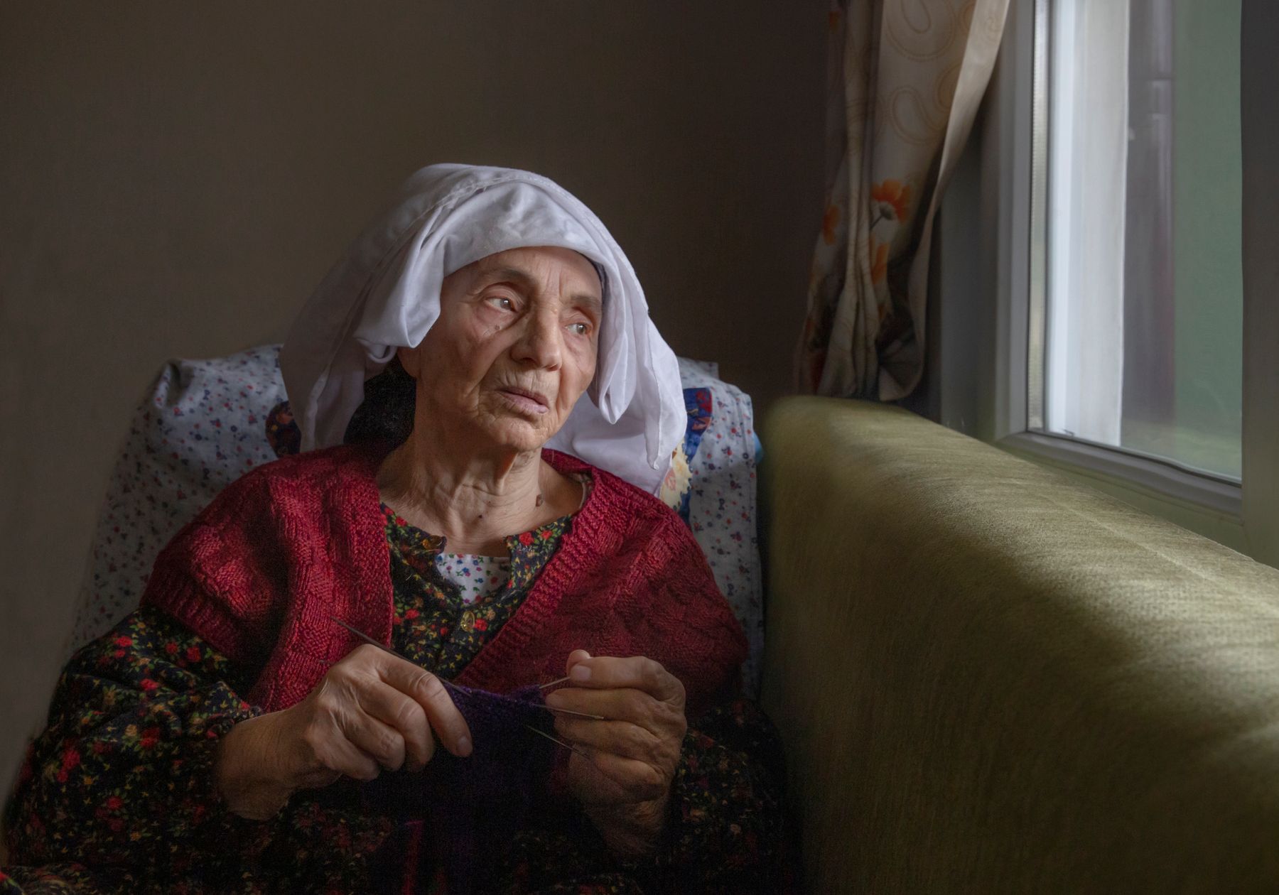 Türkiye’de kendi evinde pencere yanında oturan yaşlı bir kadın